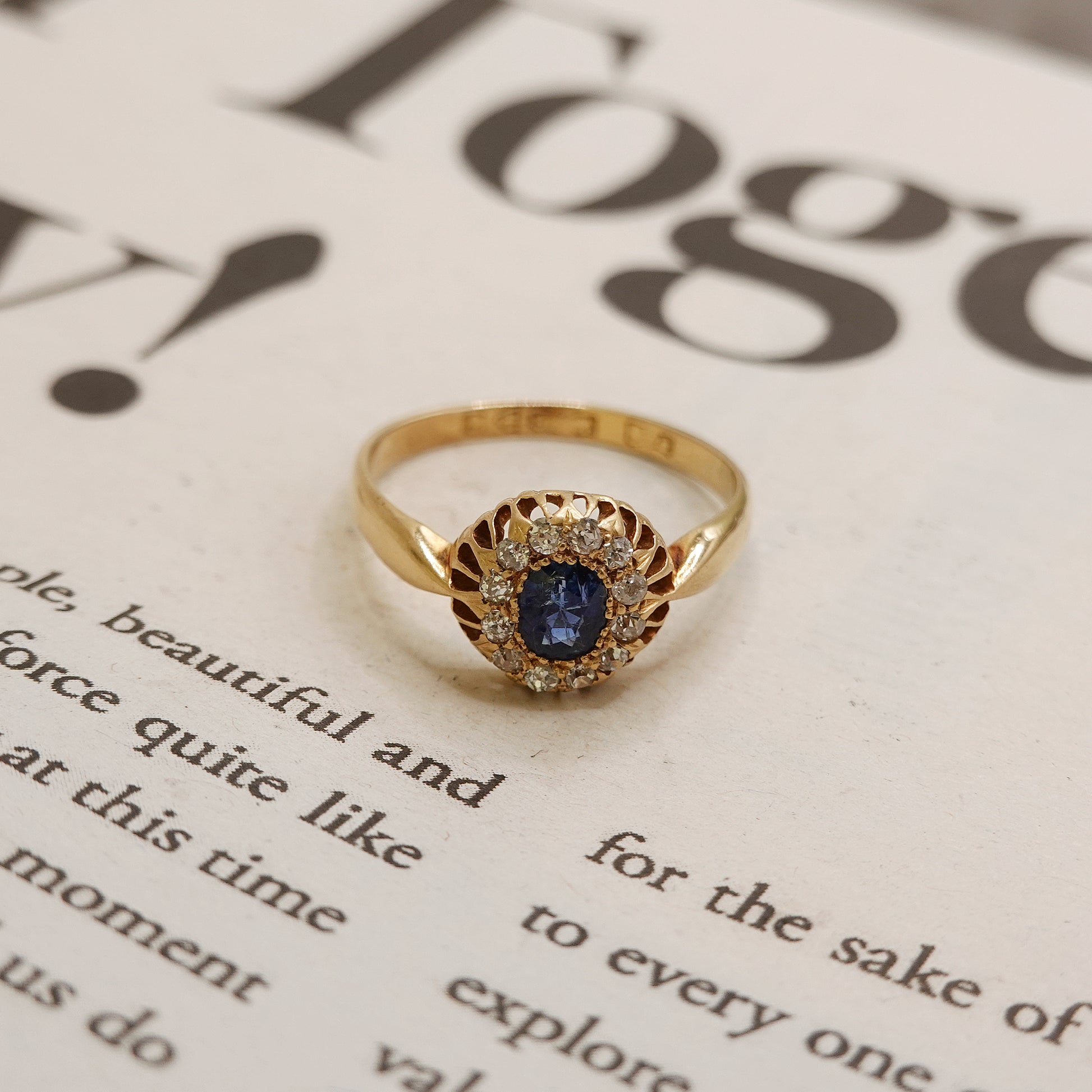 Gold ring with a blue gemstone on a book page