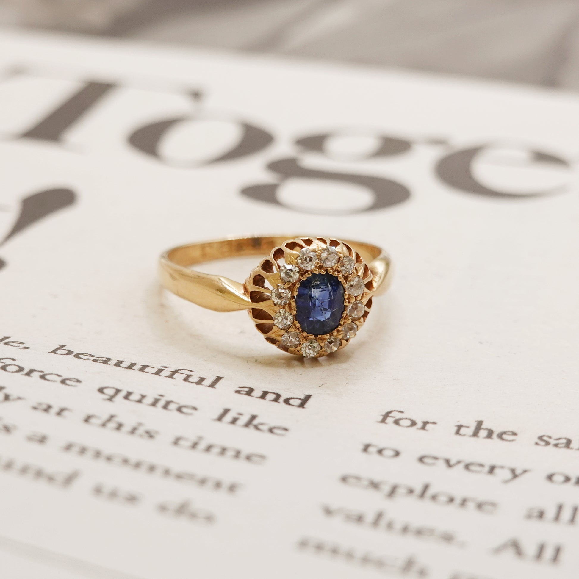 Gold ring with a blue gemstone on an open book