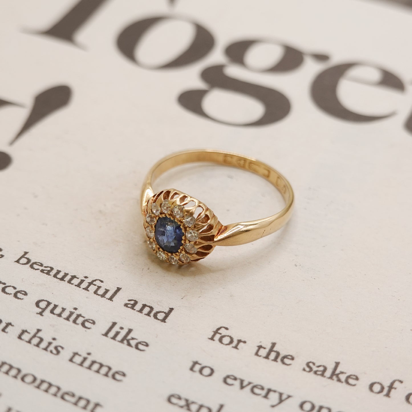 Gold ring with a blue gemstone on a magazine page