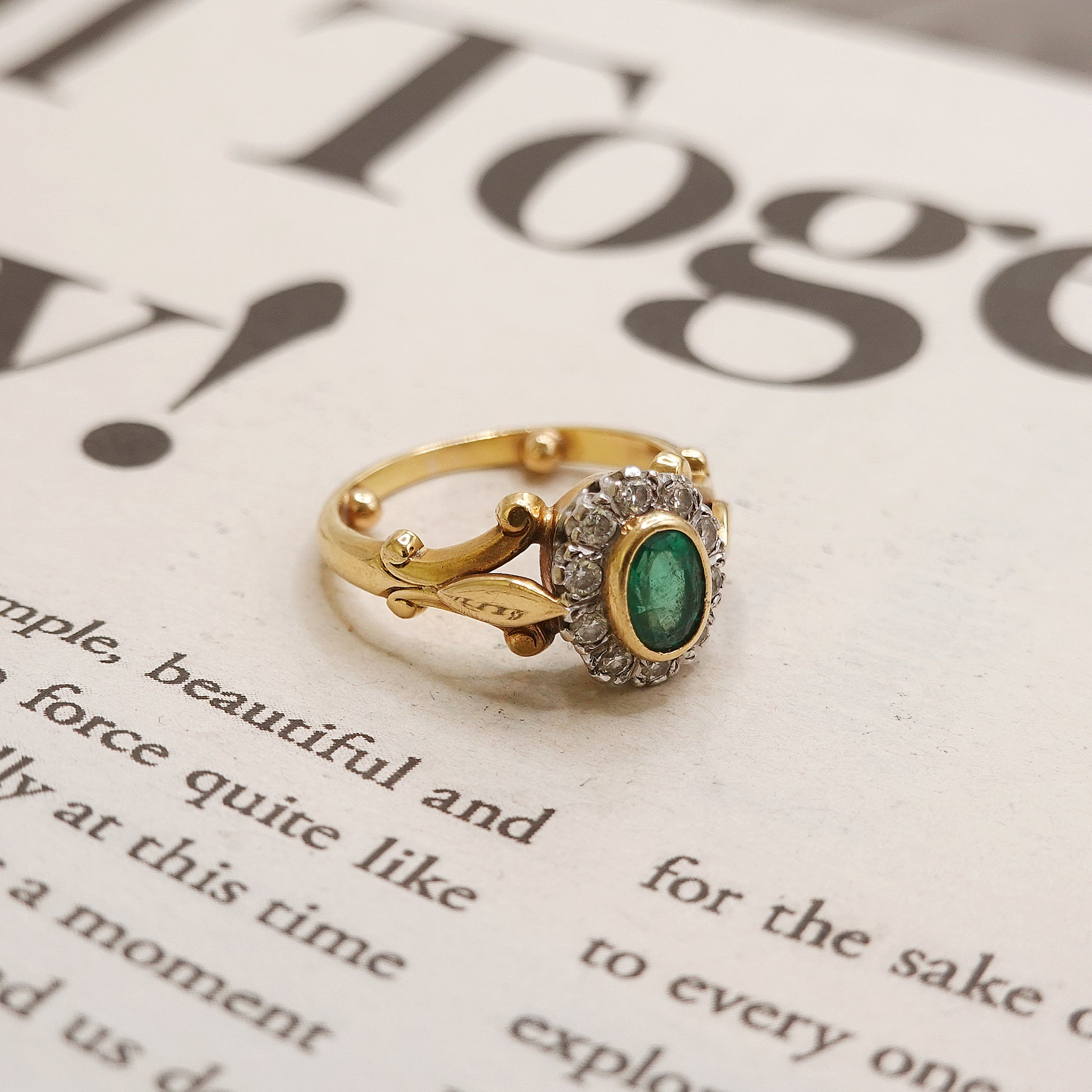 Gold ring with a green gemstone on a printed page