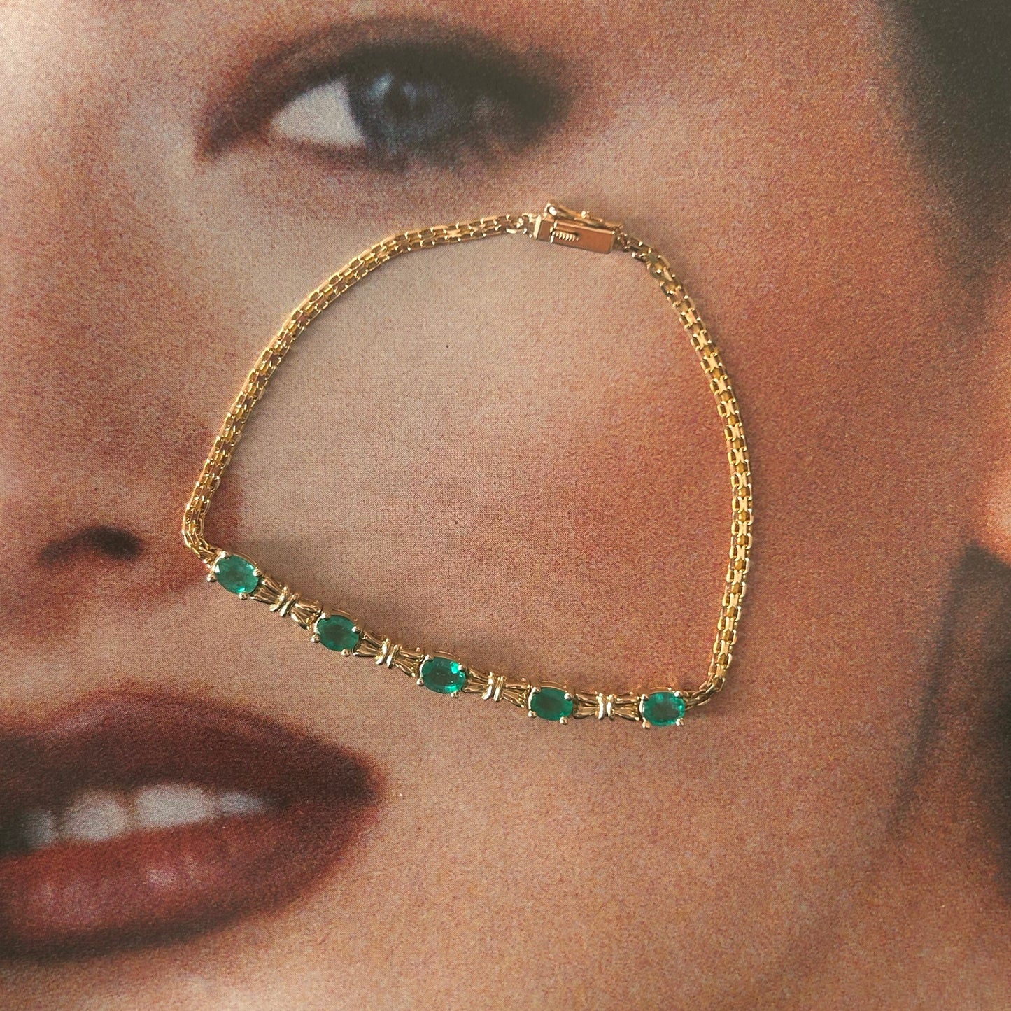 Gold bracelet with green gemstones on a close-up of a person's face