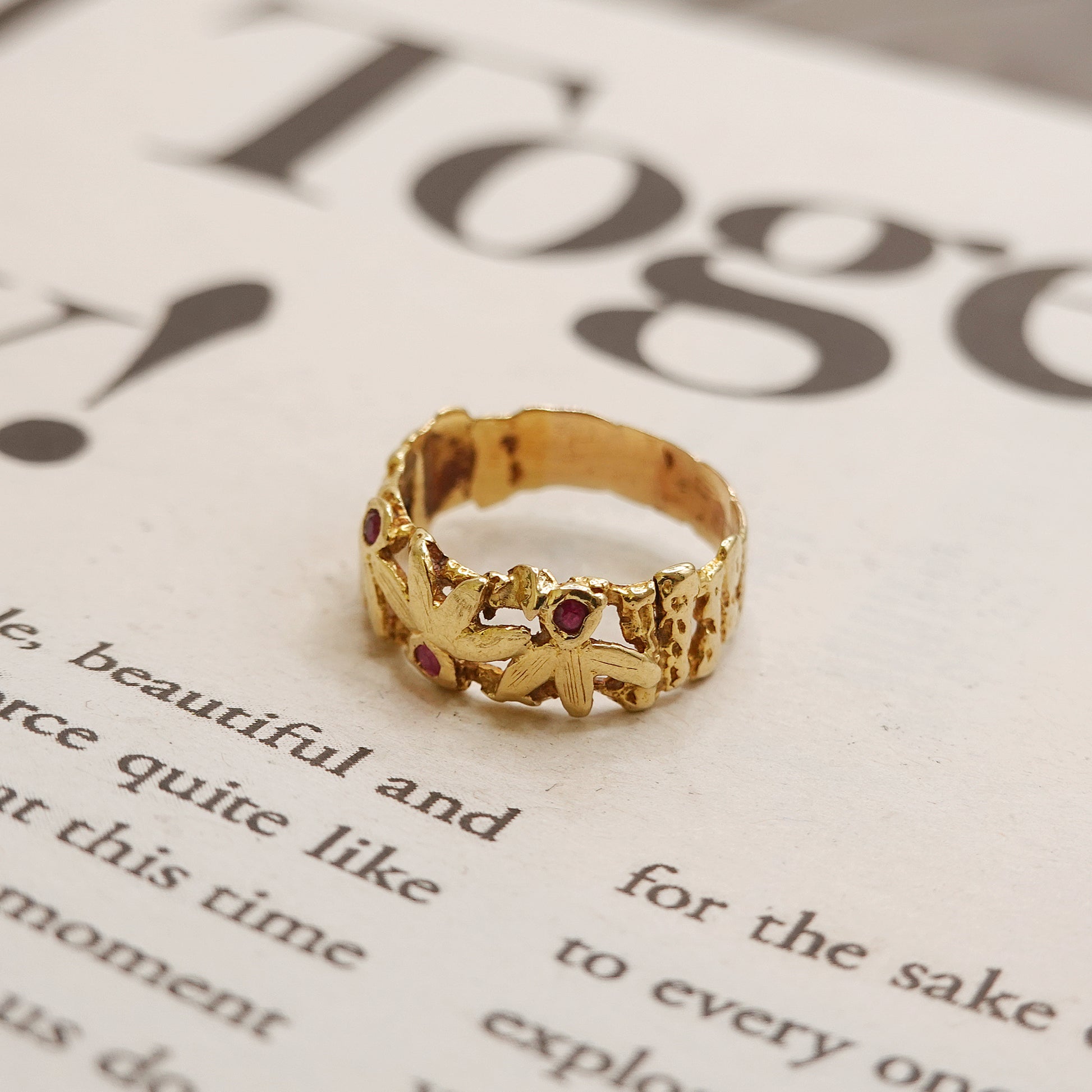 Gold ring with red ruby stones on a piece of paper