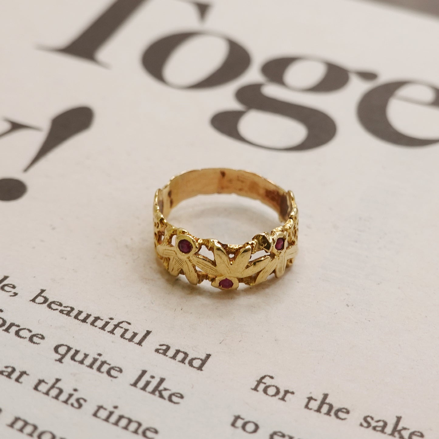 Gold ring with red ruby stones on a magazine page