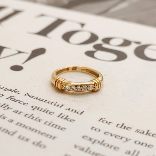Gold ring with diamonds on a newspaper background