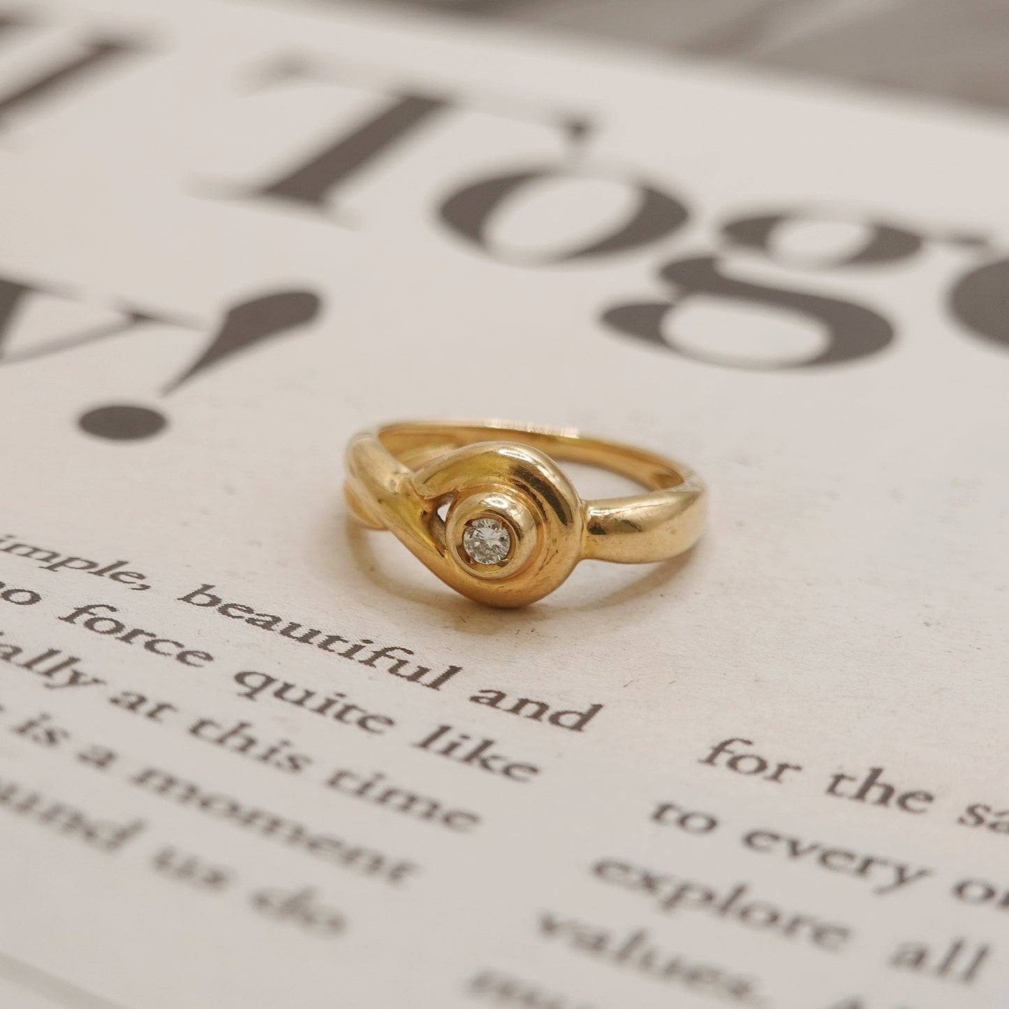 Gold ring with a diamond on a book page