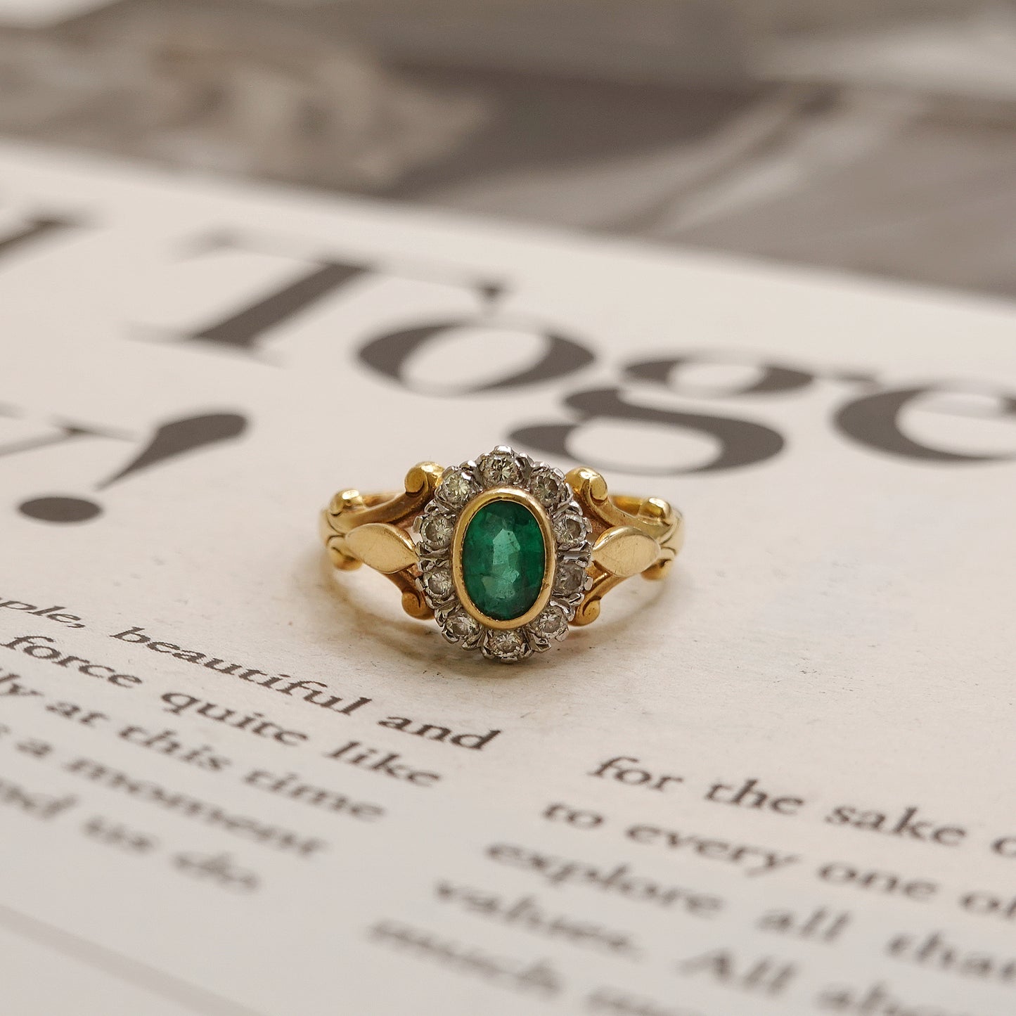 Gold ring with a green gemstone on an open book