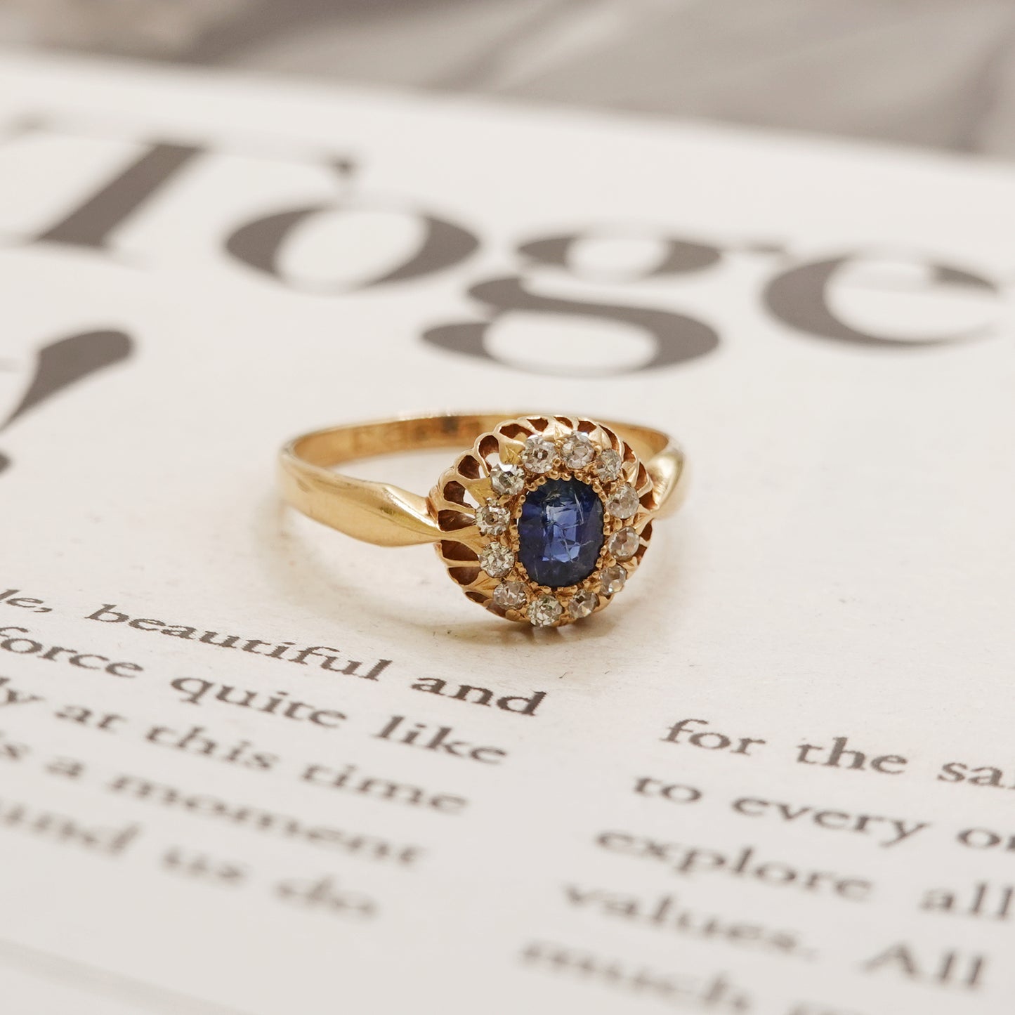 Gold ring with a blue gemstone on an open book