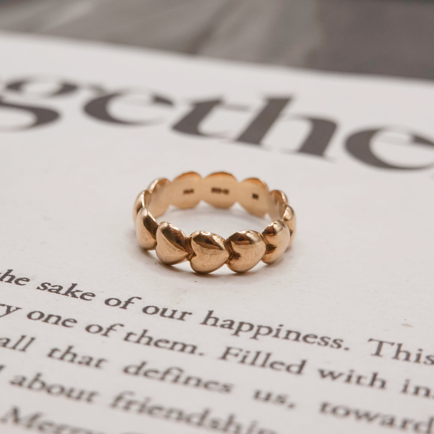  gold heart ring on a piece of paper with text