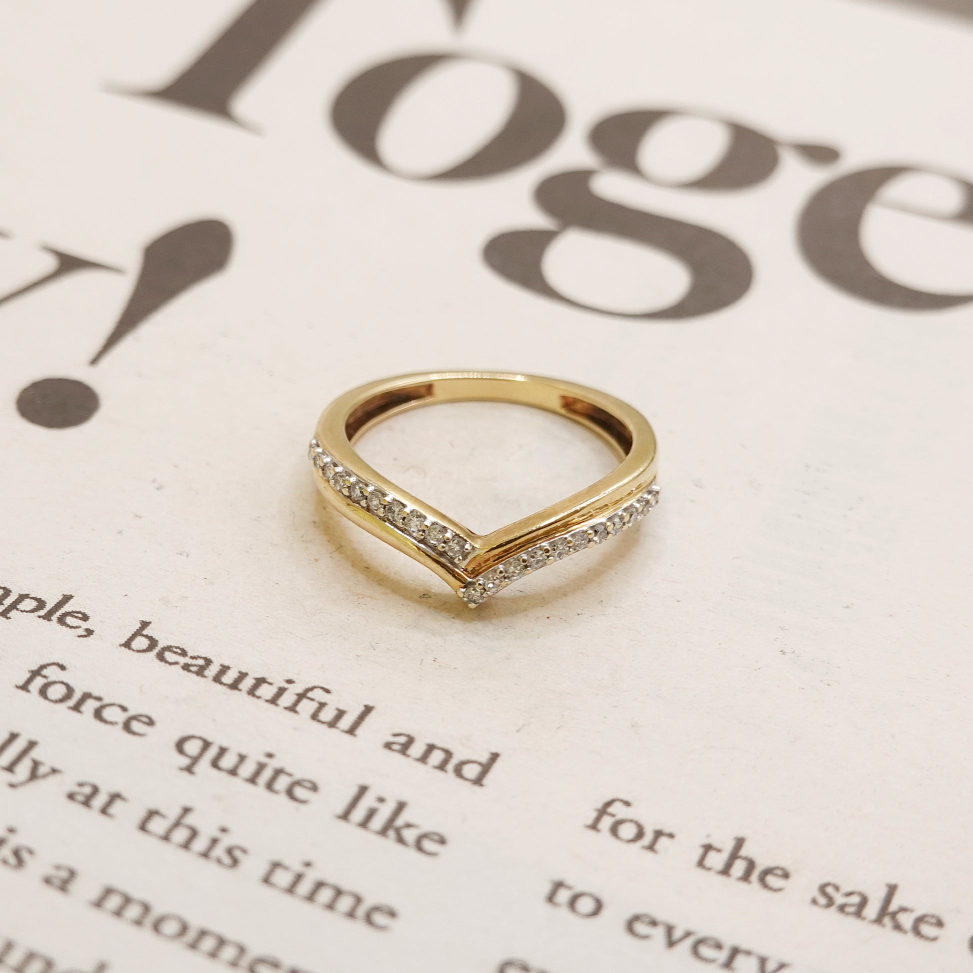 Gold ring with small diamonds on a newspaper background
