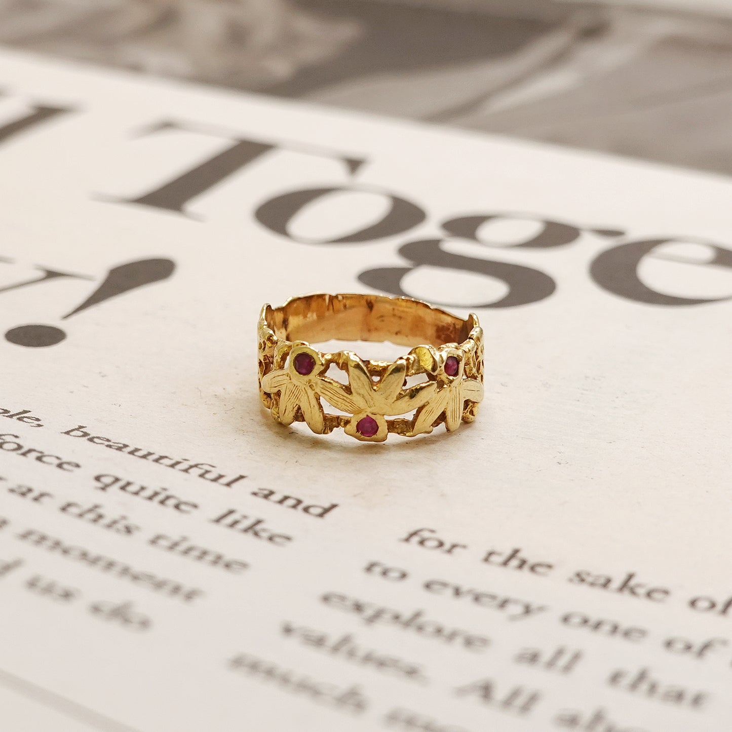 Gold ring with red ruby stones on a newspaper background