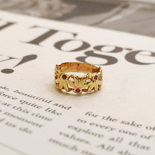 Gold ring with red ruby stones on a newspaper background