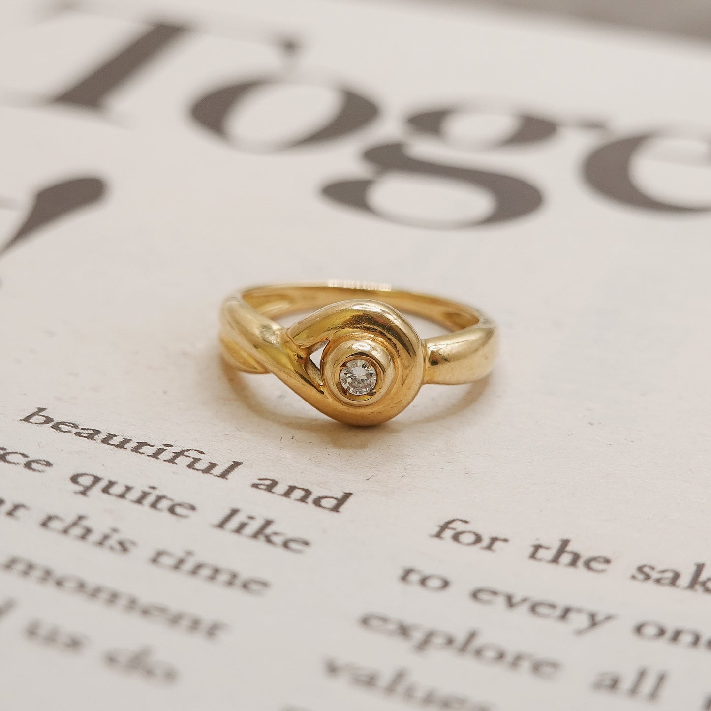 Gold ring with a diamond on a piece of paper