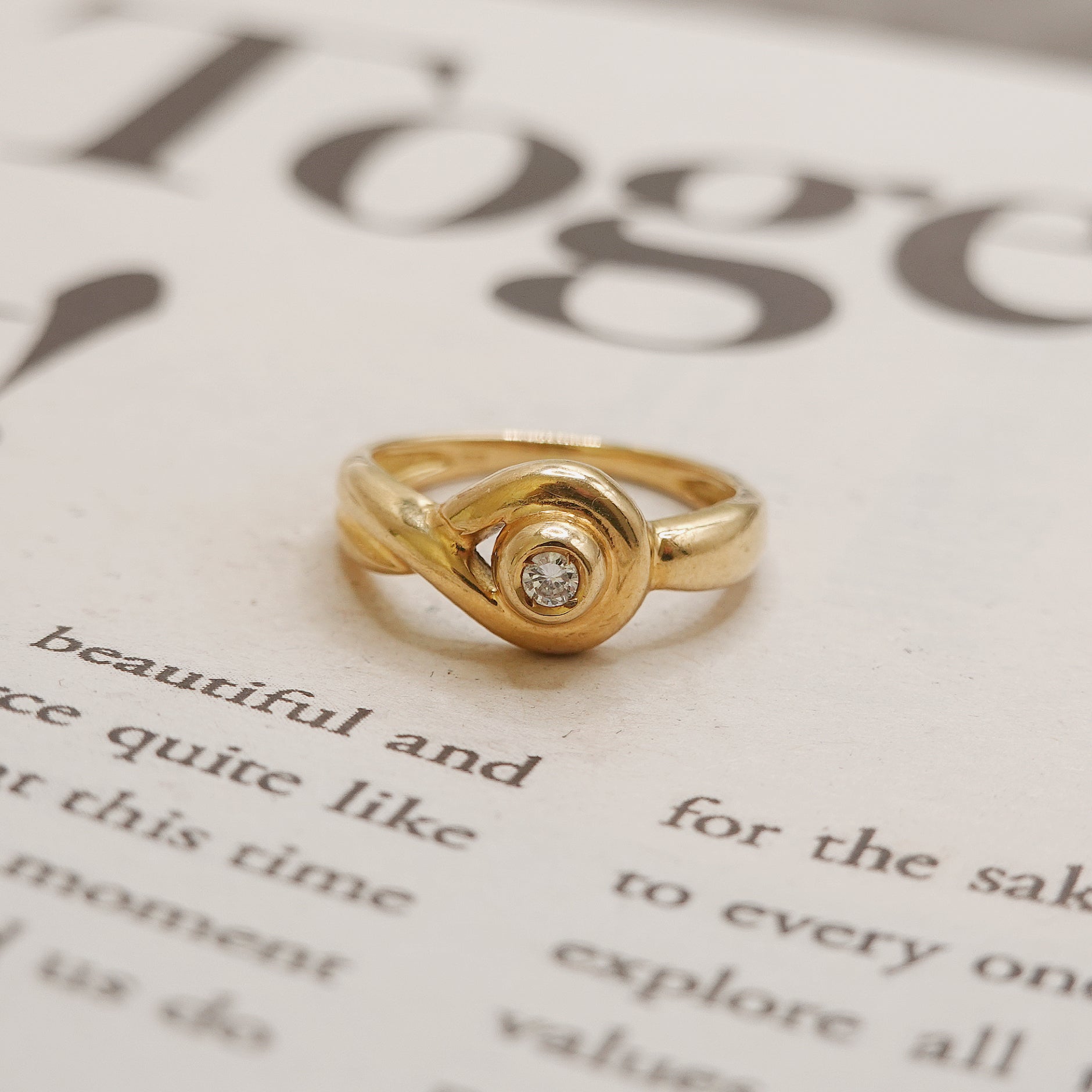 Gold ring with a diamond on a piece of paper