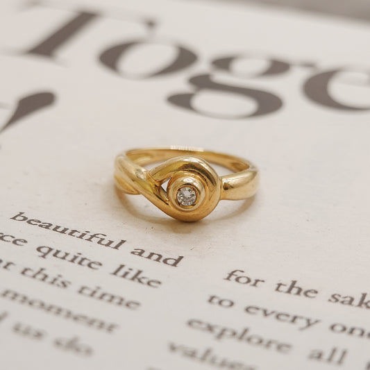Gold ring with a diamond on a piece of paper