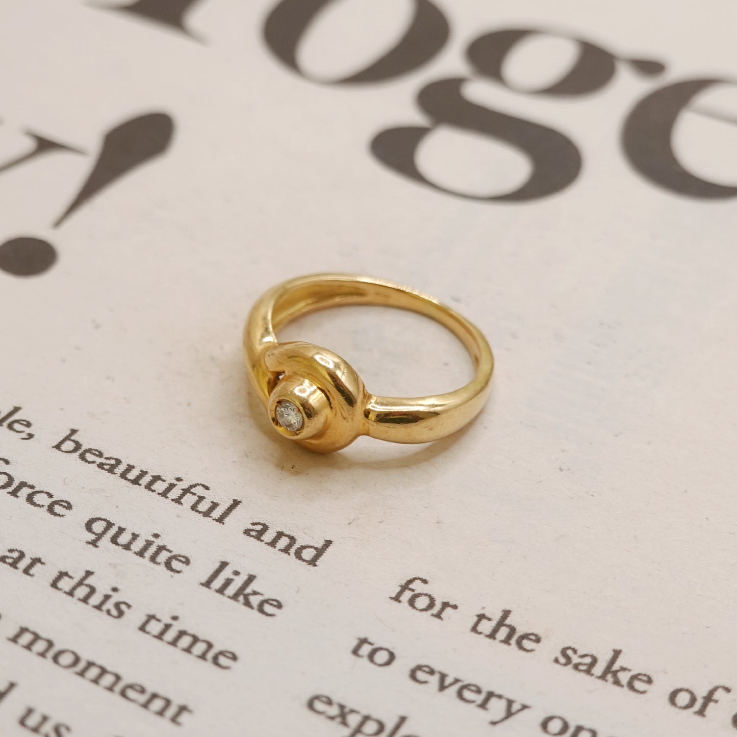 Gold ring with a diamond on a piece of text paper