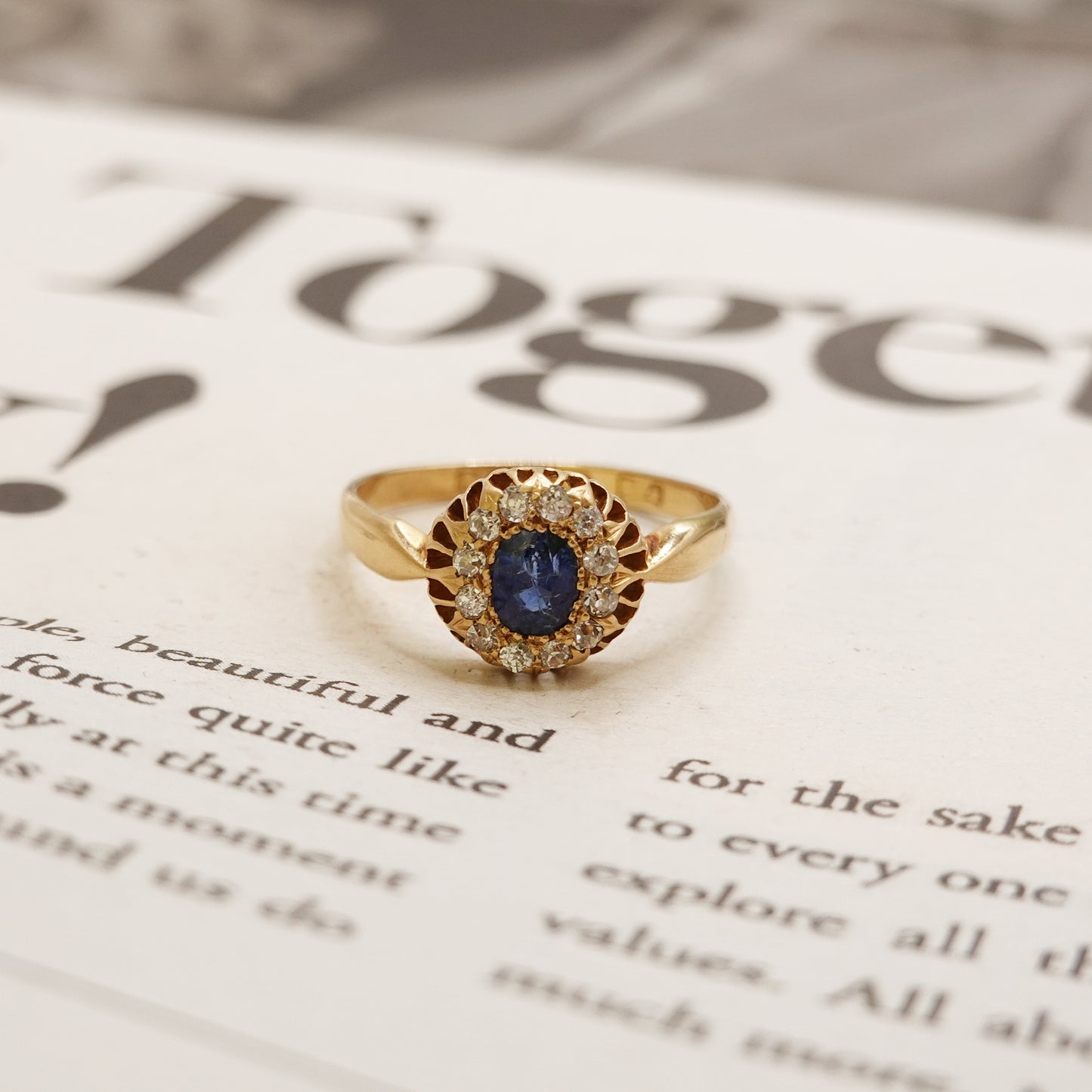 Gold ring with a blue gemstone on a newspaper background